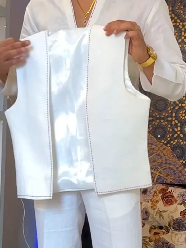 White three-piece outfit with V-neck shirt, sleeveless vest and trousers on hanger