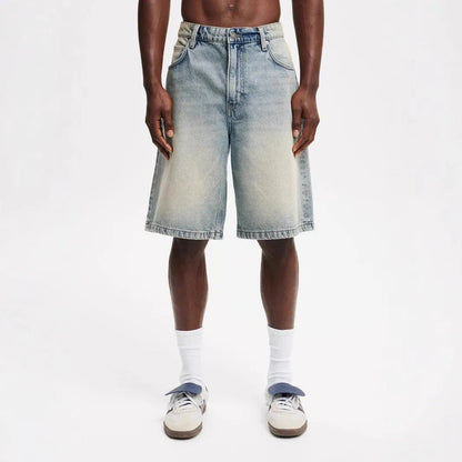 Men's light blue loose straight-leg cotton jeans laid flat, showing the front design and fifth-pants length.
