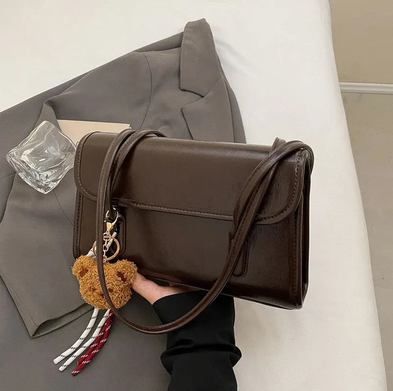 Brown women's square shoulder bag with double straps and pendant accessory