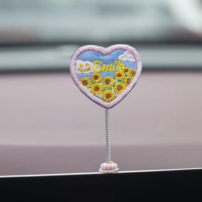 Set of six small yellow PVC duckling car decorations and one cartoon sign on a car dashboard.