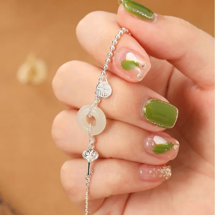 Silver women's bracelet with Hetian jade stones and a geometric peace buckle charm.