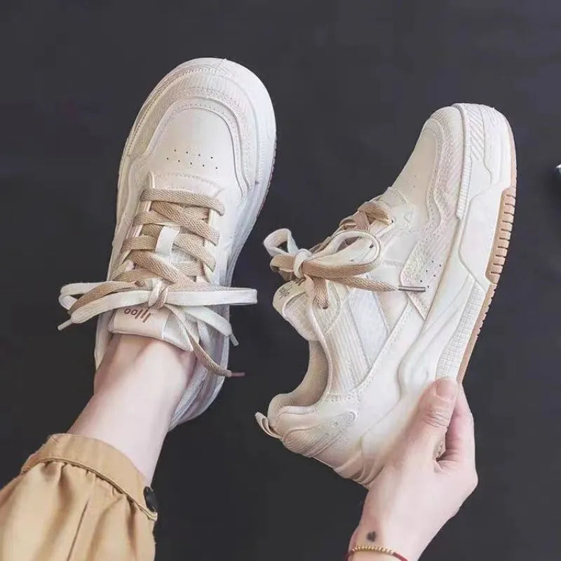 Pink and milky white low-top height-increasing sneakers with a rubber sole.