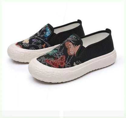 Women's black and white slip-on canvas shoes with round toe and decorative stitching