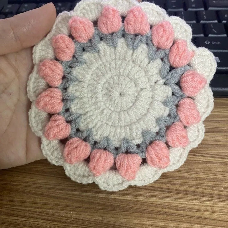Handmade woven floral coaster in cotton and linen, showing pink, purple, red, and yellow colour options