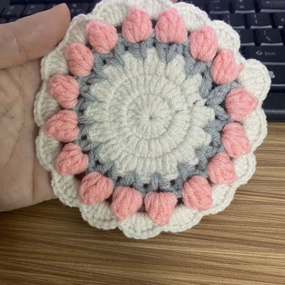 Handmade woven floral coaster in cotton and linen, showing pink, purple, red, and yellow colour options