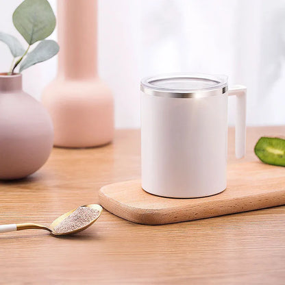 White automatic stirring coffee cup with magnetic base on a wooden table, showing simple solid-colour design.