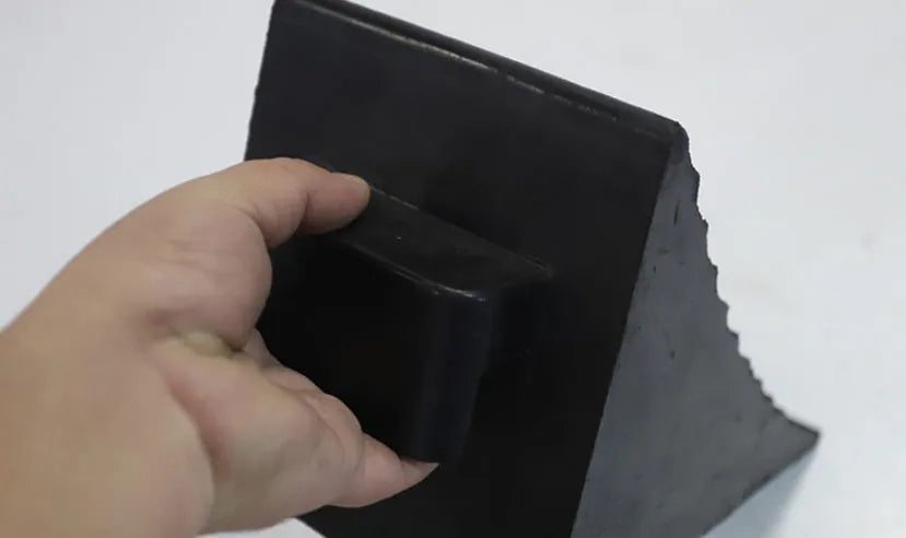 Portable car anti-slip retainer wedge with isosceles triangle design on a ramp.