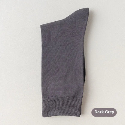 Pair of solid-colour men's mid-calf socks made from combed cotton on a wooden background