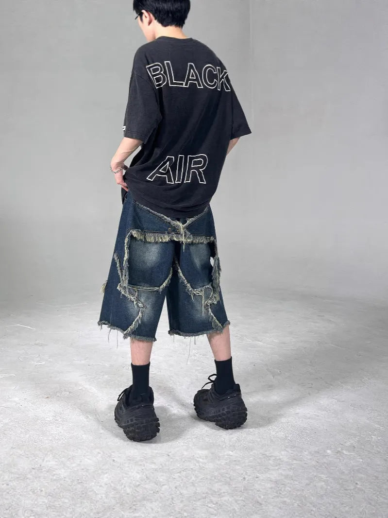 Blue men's denim shorts with frayed hem, loose fit, and a white five-pointed star patch on the leg.