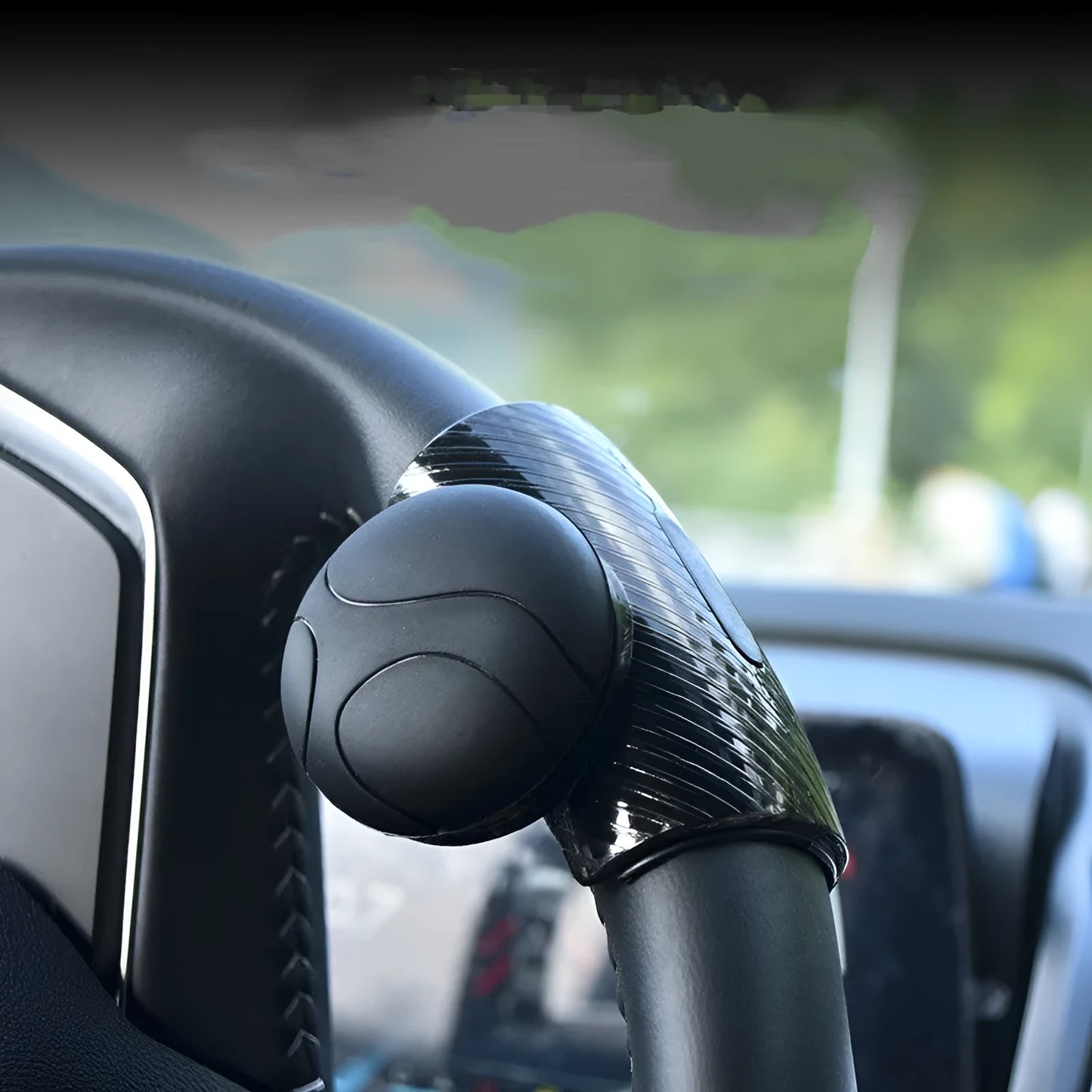 Black steering wheel assist ball with silicone grip mounted on car steering wheel