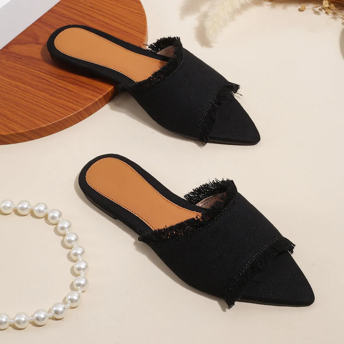 Women's denim flat slippers with tassel detail in apricot colour, showing leather lining.