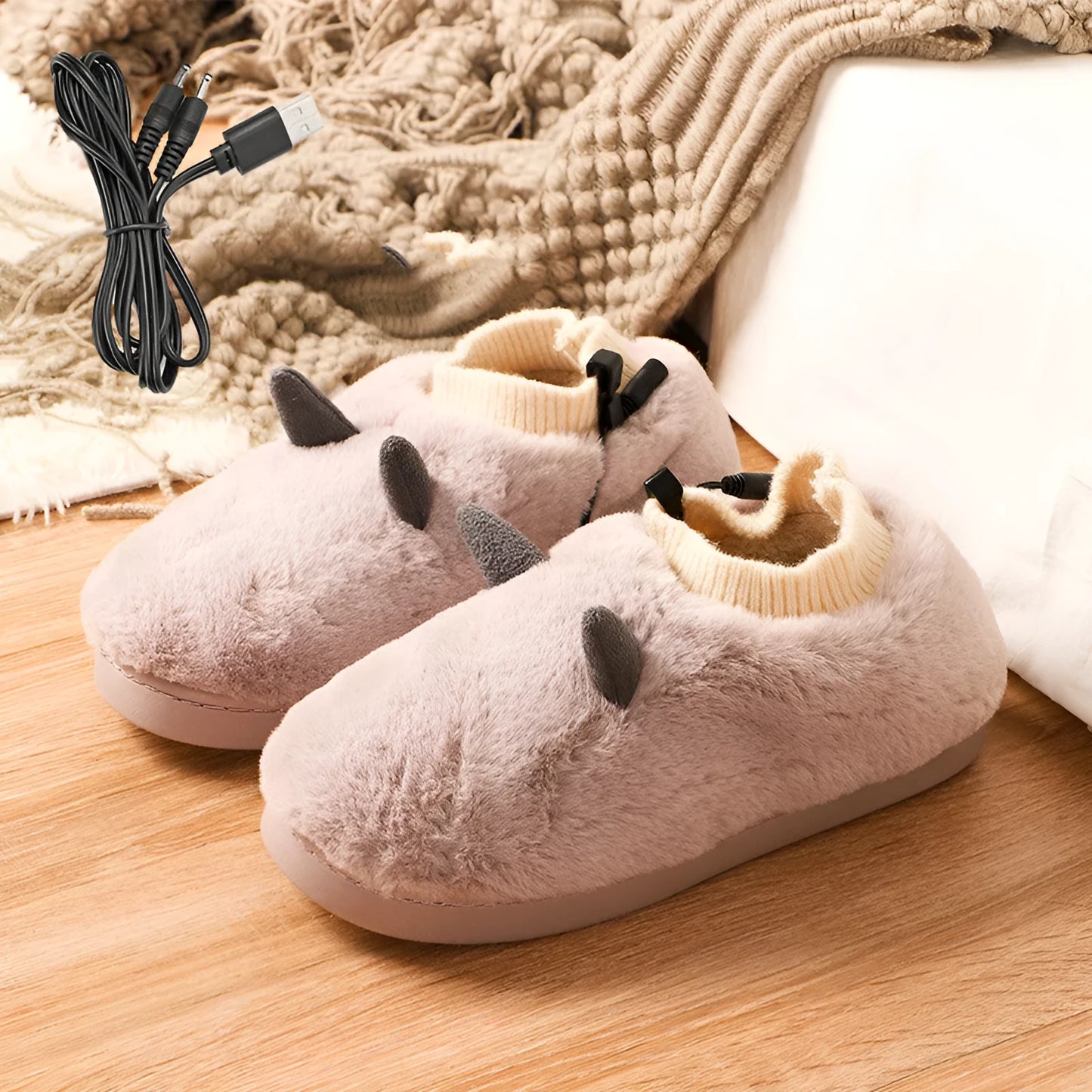 USB heating slippers in black plugged into a laptop, showing the cable and soft velvet upper.