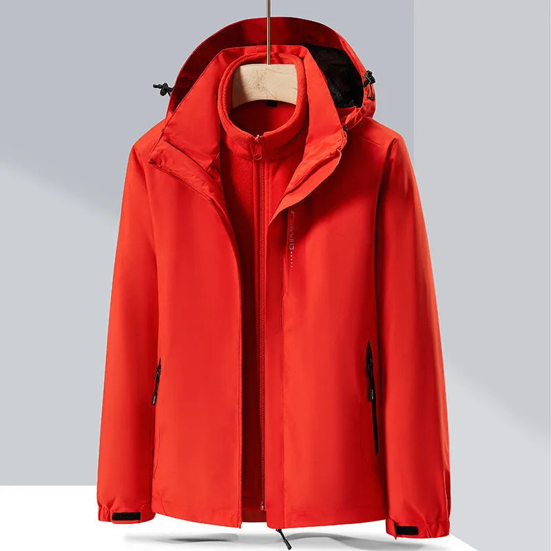Men's fluorescent coloured waterproof mountaineering suit with removable fleece liner, shown in a hiking setting.