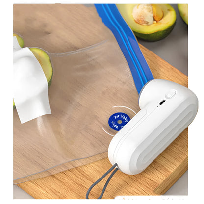 White handheld vacuum sealing machine with USB charging port on a kitchen counter.