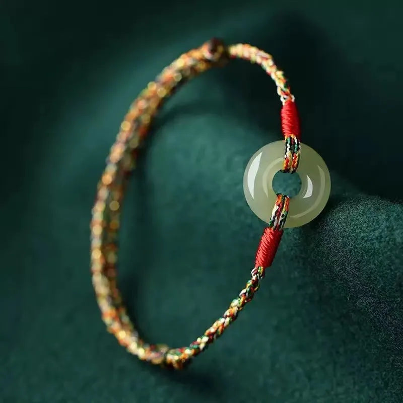 Colourful woven rope bracelet with silver peace buckle fastening on wrist
