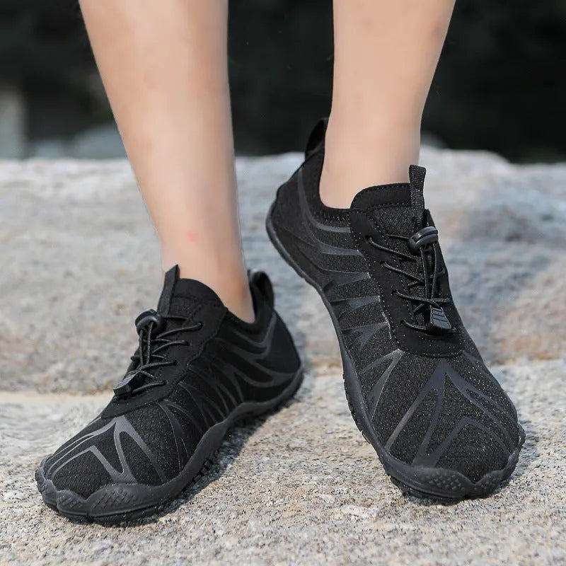 Men's and women's low-top breathable sports running shoes with a natural rubber sole on a hard ground surface.