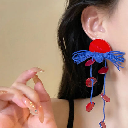 Handmade geometric women's earrings with blue resin flower and cloth material on silver needle setting.