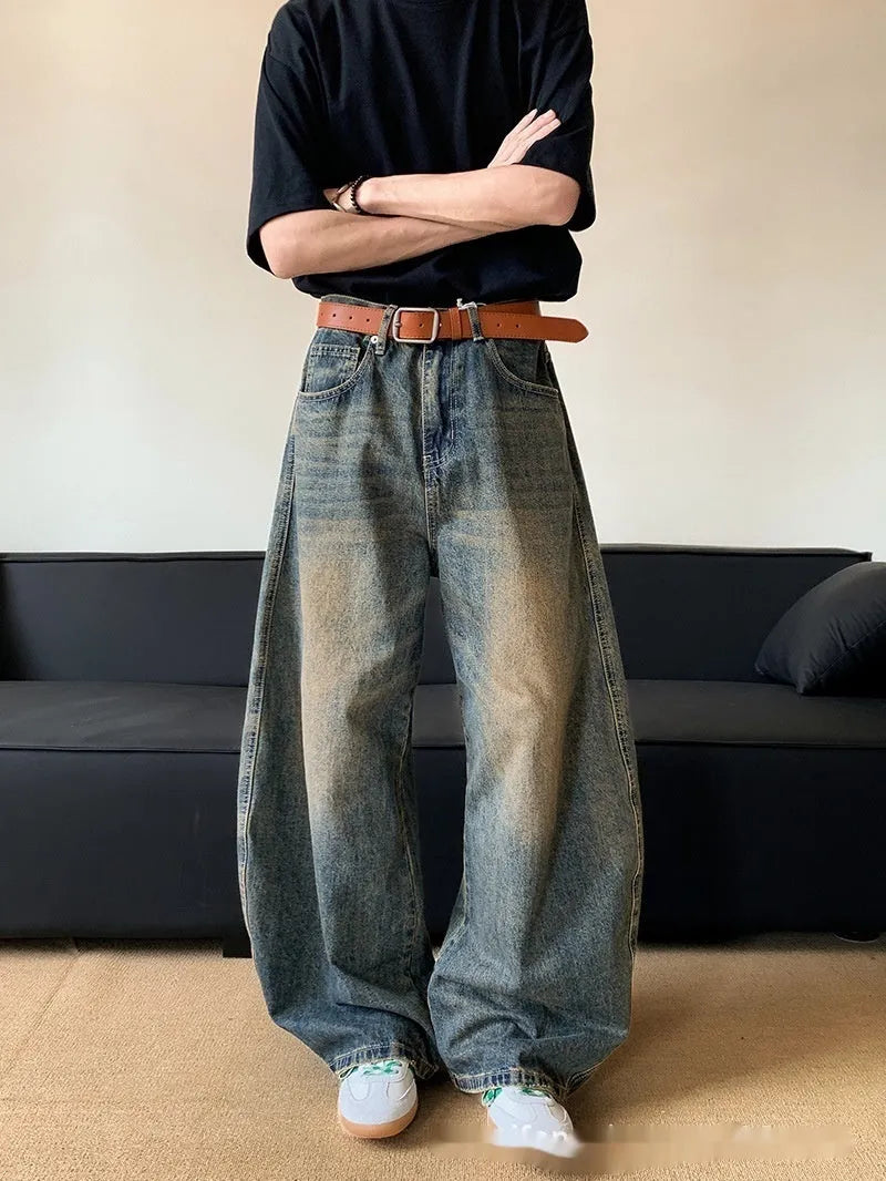 Men's distressed retro blue jeans with a slim wide-leg cut and mid waist.