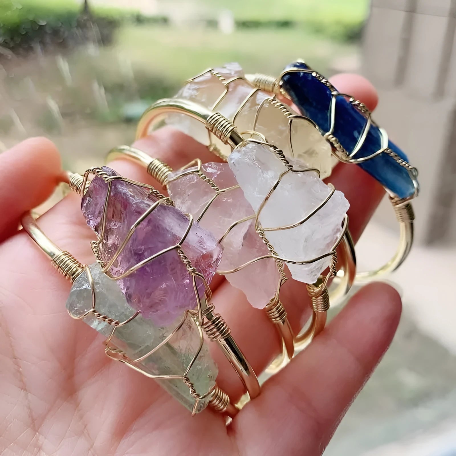 Natural gold winding crystal rough stone bracelet with unshaped geometric design on a wrist.