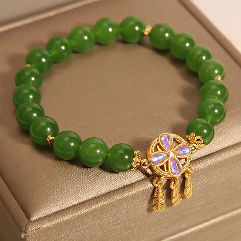 Green jasper crystal four-leaf clover dream catcher pendant on a women's bracelet.