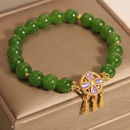 Green jasper crystal four-leaf clover dream catcher pendant on a women's bracelet.