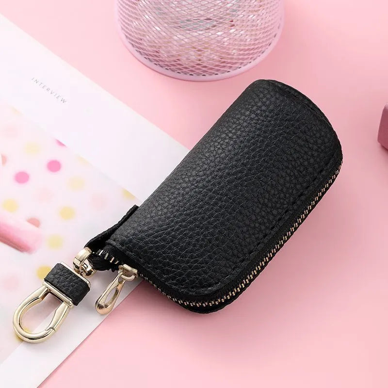 Minimalist black PU leather key wallet with a silver metal zipper closure.