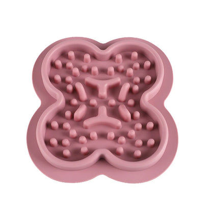 A raised silicone pet licking pad placed on a floor, showing its textured surface and non-slip base.