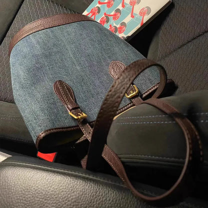 Large blue denim patchwork bucket handbag with one shoulder strap.