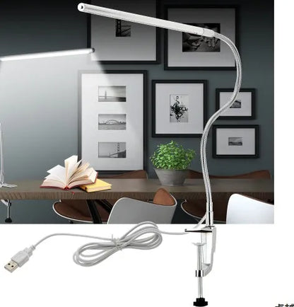 Silver aluminium alloy USB-powered LED nail table lamp with a long arm clip attached to a table edge.