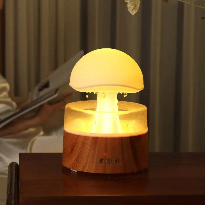 White cloud-shaped humidifier emitting mist with multicoloured LED light and water droplets