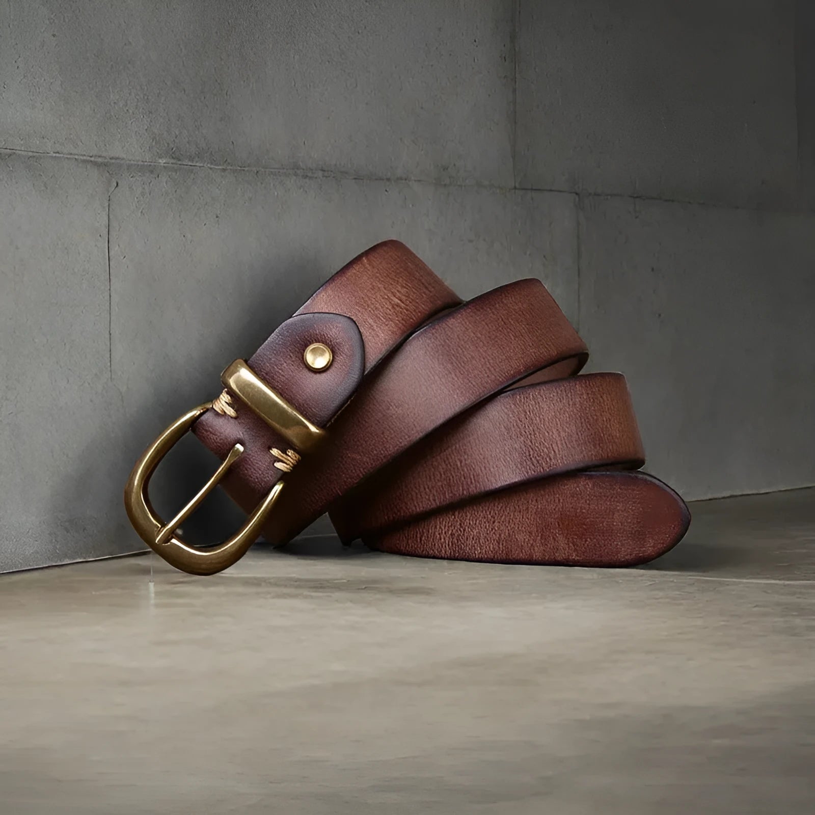 Men's black cattlehide leather jeans belt with a copper pin buckle shown on a flat surface.