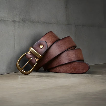 Men's black cattlehide leather jeans belt with a copper pin buckle shown on a flat surface.