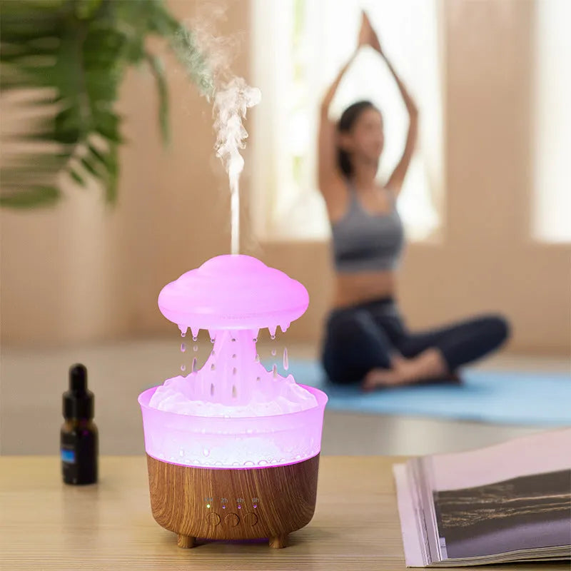 Wood grain rain cloud humidifier with LED lights and water drip feature on a table