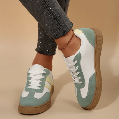 Women's green and white retro-style low-top casual pumps with cross straps and a flat rubber sole.