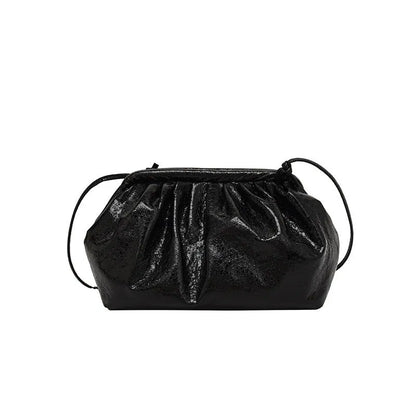 Rose red crossbody bag with hair clip strap clasp on a table, showing shell shape and front zipper.