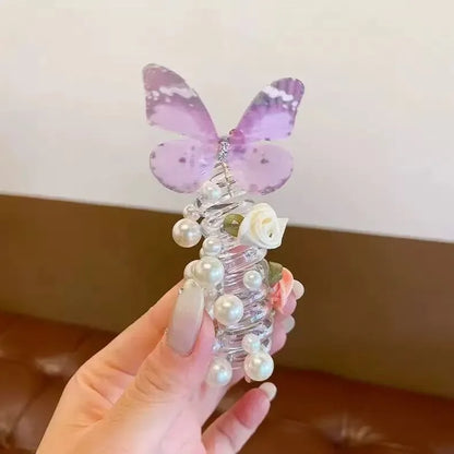 Colourful butterfly and pearl elastic hair band for children on a white background.