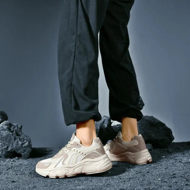 Men's beige and black collapse flat casual sneakers with low heel on a plain background