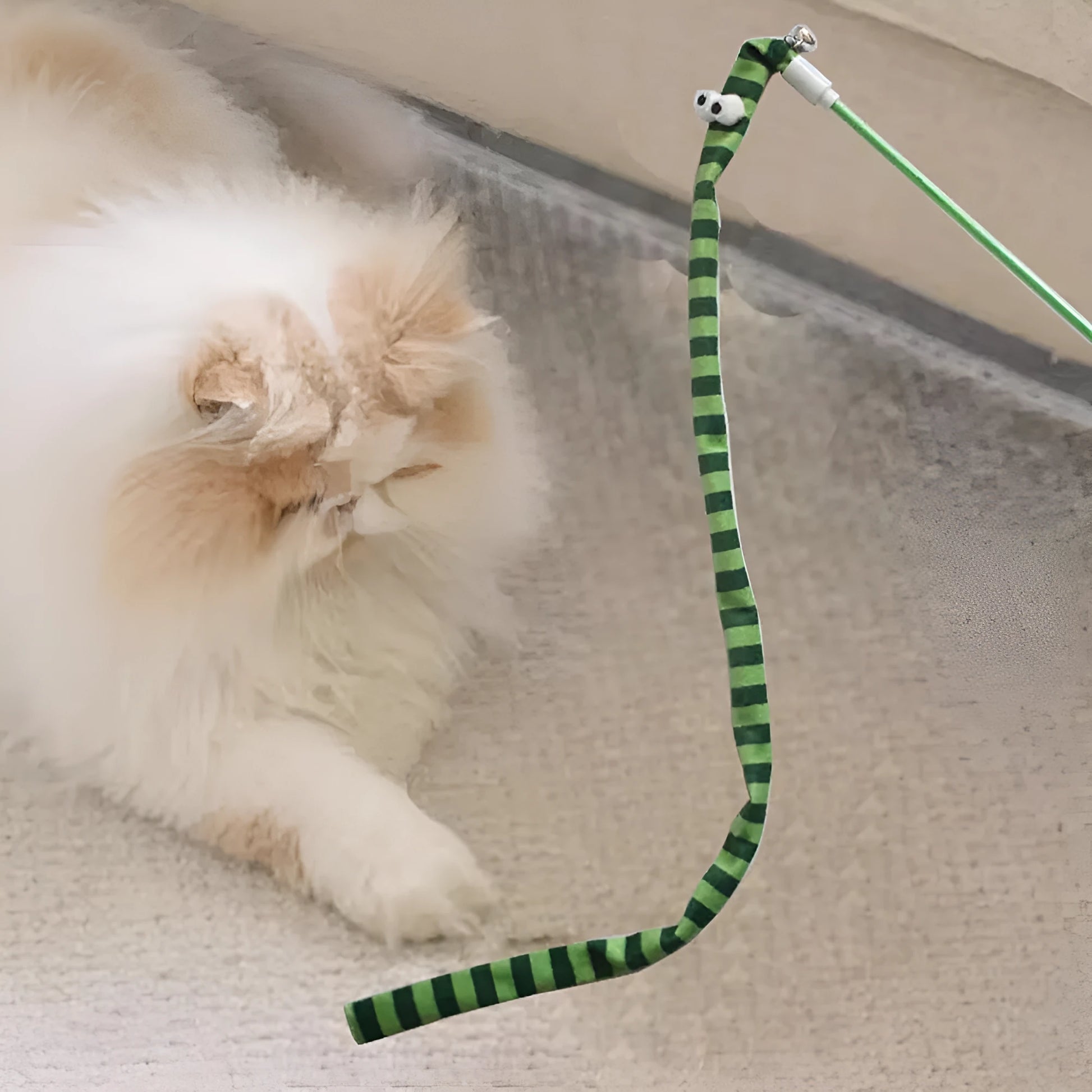 Interactive cat wand toy with a polycarbonate handle and a long green plush strip with a bell.