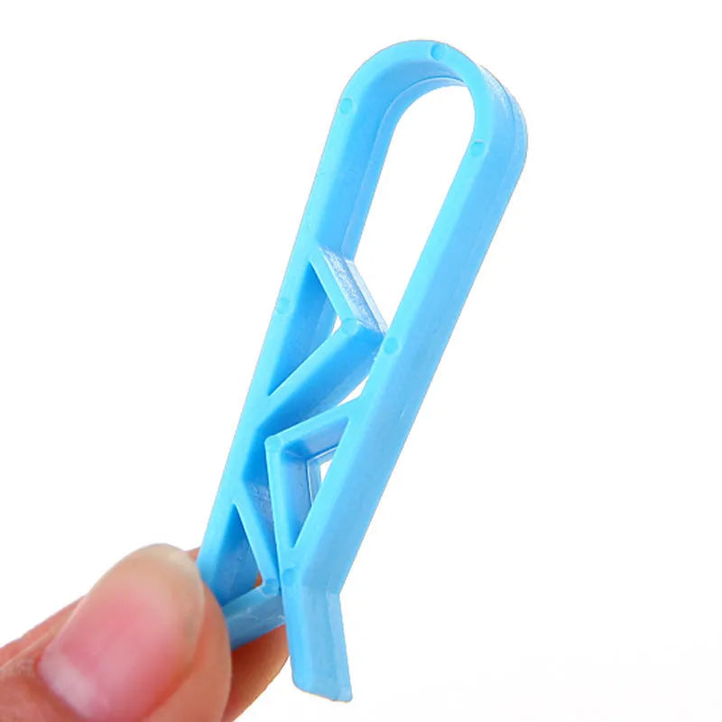 A white polypropylene plastic clip for holding a rubbish bag onto the rim of a bin.