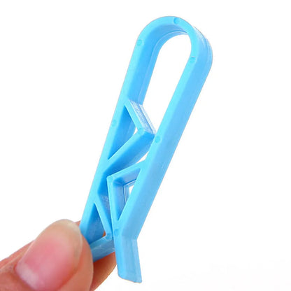 A white polypropylene plastic clip for holding a rubbish bag onto the rim of a bin.
