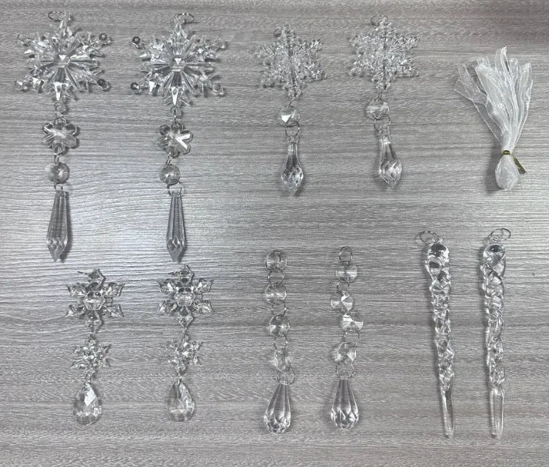 Set of ten clear acrylic icicle-shaped Christmas tree ornaments with white ribbons on green pine branches.