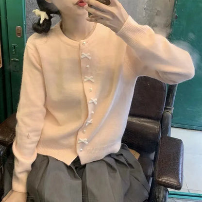 Women's acrylic cardigan sweater with pearl button bow detail in light yellow colour