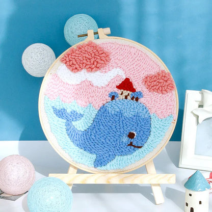 Handmade embroidery kit with cartoon animal designs on linen fabric including flamingo, whale and deer patterns