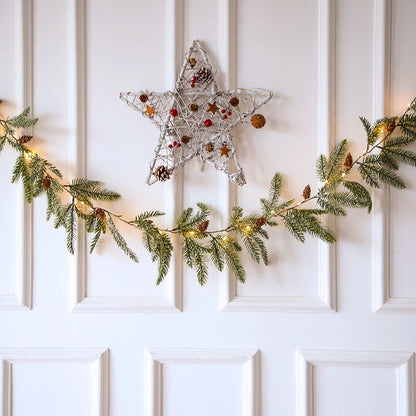 Decorative copper leaf string lights with rattan and pine needle accents, creating a cozy, festive atmosphere