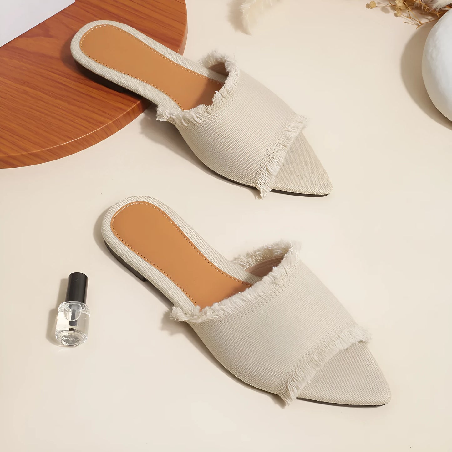 Women's denim flat slippers with tassel detail in apricot colour, showing leather lining.