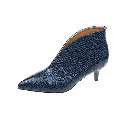 Women's black V cut Martin boots with a pointed embossed toe and a chunky heel.