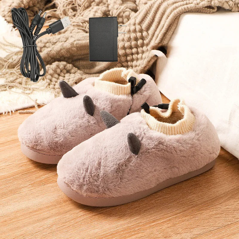 USB heating slippers in black plugged into a laptop, showing the cable and soft velvet upper.