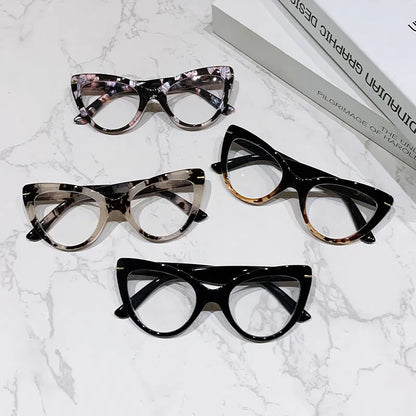 Women's black floral cat's eye reading glasses with large frames on a wooden table.