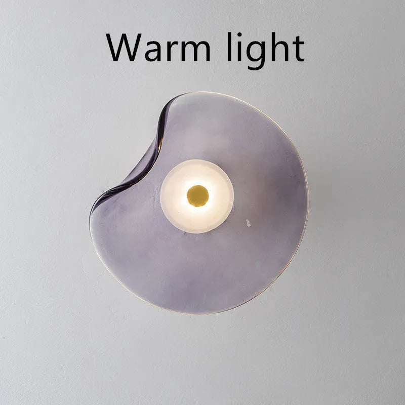 Round glass wall lamp mounted beside bed in cognac colour with 220V operation for bedside lighting