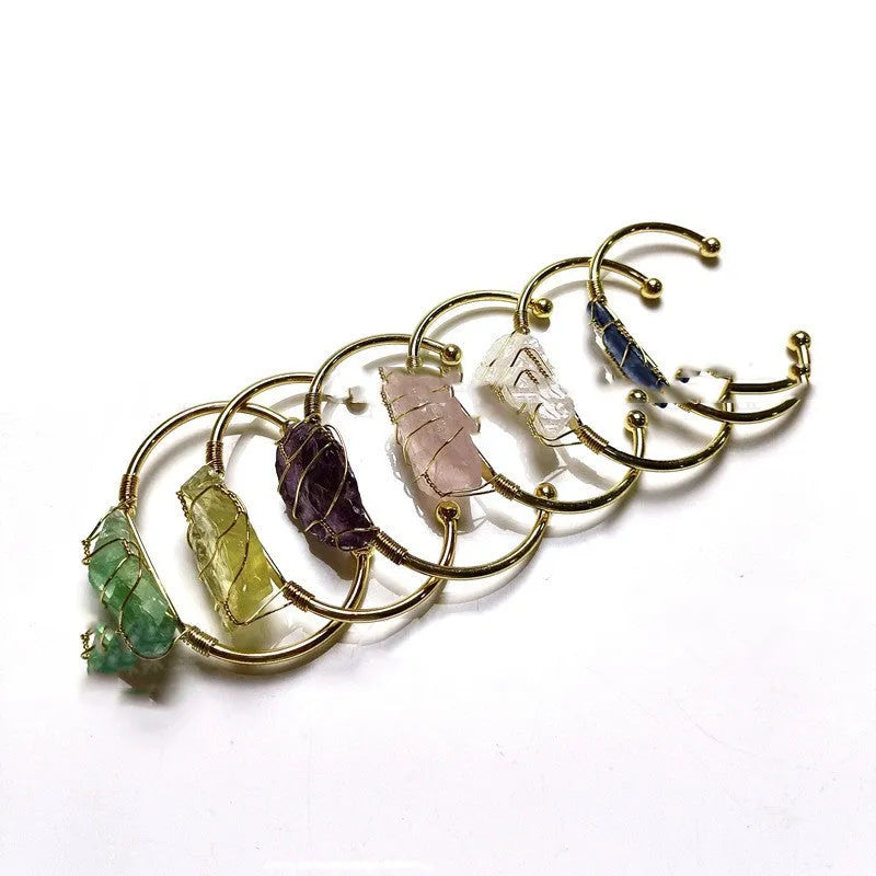 Natural gold winding crystal rough stone bracelet with unshaped geometric design on a wrist.